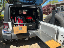 Load image into Gallery viewer, Overland Vehicle Storage system for SUV, Jeep Jk / JL, 4Runner. View of  system fully loaded in rear of Jeep JK, matched with Outback Adventure tailgate table with bamboo cutting board.