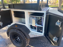 Load image into Gallery viewer, Tribe Basecamp Overland Trailer. View of passenger side storage, on-board battery and inverter